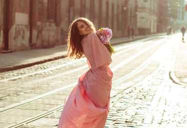 a sugar mommy in a pink dress is dancing on a brick road in Melbourne.