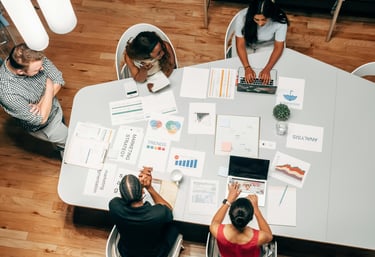 Equipo trabajando en oficina, con portátiles y gráficos