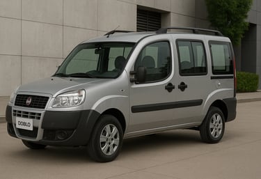 Fiat Doblò prata visto de lado em ambiente externo, estacionado próximo a prédio moderno.
