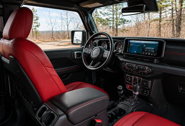 Interior do Jeep Rubicon com bancos vermelhos e painel moderno com multimídia