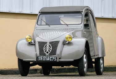 Citroën 2CV clássico cinza visto de frente com design icônico e faróis redondos originais