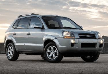 Hyundai Tucson prata visto de frente e de lado em cenário externo ao entardecer
