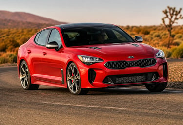 Kia Stinger GT vermelho rodando em estrada desértica ao entardecer.