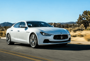 Maserati Ghibli branco em estrada desértica com visual esportivo de luxo