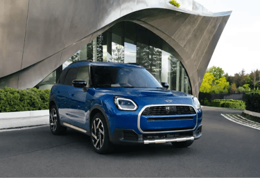MINI Countryman azul estacionado diante de edifício moderno com design futurista
