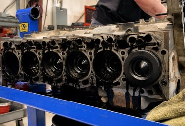 Motor Cummins desmontado em oficina mostrando desgaste interno e cilindros expostos.