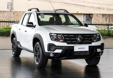 Renault Oroch branca exibida em showroom com iluminação natural e piso brilhante.