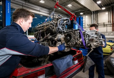 Equipe técnica realizando a retirada do motor de um veículo para manutenção