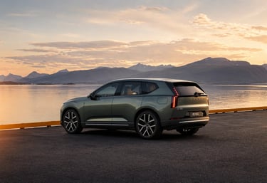 Volvo EX60 elétrico estacionado à beira de lago com montanhas ao fundo e visual sofisticado