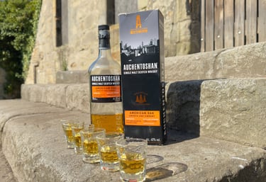 glasses of whisky in front of a bottle of whisky