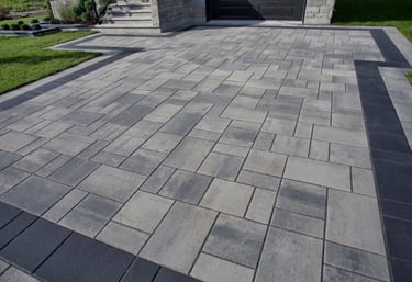 a driveway with light and dark pavers, and a dark border all around