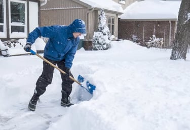 a person shoveling the snow from his driveway