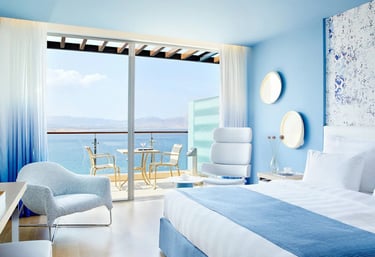 A spacious bedroom with a large bed and a balcony, symbolizing premium accommodation and comfort.
