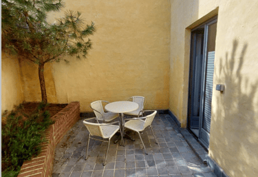 Cour intérieure avec mobilier et végétation accessible depuis un bureau