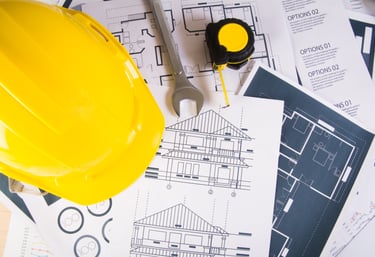 capacete amarelo sobre papéis em uma mesa