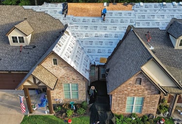 Roofing crew lays synthetic underlayment on roof replacement job for condominiums in Tyler, TX