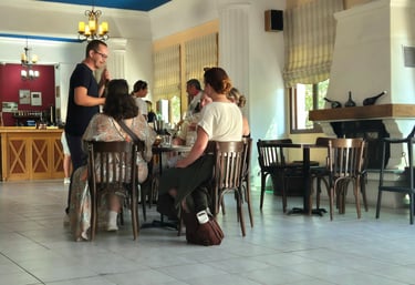 a group of people sitting at a table tasting wine 