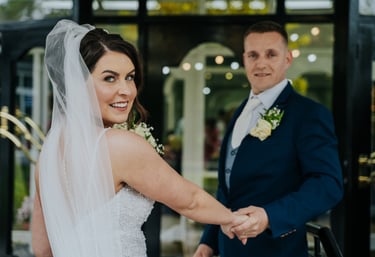 a bride and groom holding hands and smiling