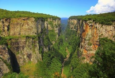 a view of a canyon with a waterfall and a waterfall