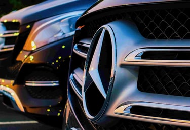 Close-up of Mercedes emblem on V-Class, showcasing premium transport services.