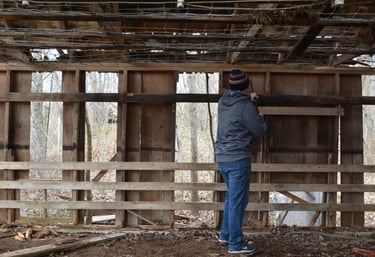 A person prying of wood from a decaying structure