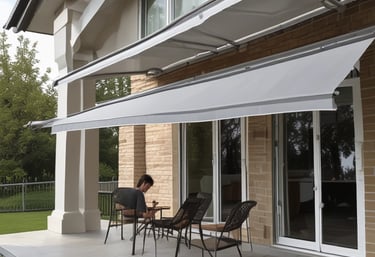 Large shade structures with net-like fabric are situated on a wooden deck overlooking a glassy, calm body of water. The sky is clear and blue, indicating a sunny day. The fabric of the shades is partially draped and flows naturally with the breeze, creating an airy and relaxed atmosphere.