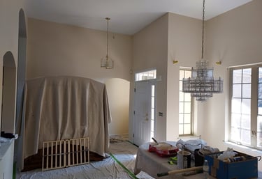a dining room with drop clothes and paint trays
