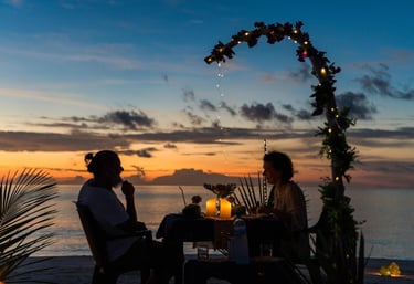 a couple sitting at a table with candles and candles