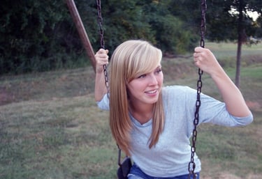 a woman sitting on a swing set