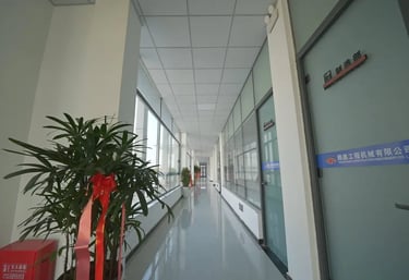 Zorulift Construction Machinery: Bright, modern office corridor to Manufacturing Dept. Clean, professional.