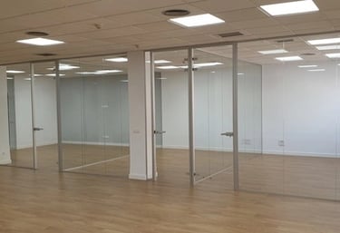 Divisoria de oficina en cristal laminar, puerta en vidrio templado altura de suelo a techo.