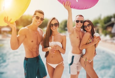 Group of stylish friends in swimwear at a Vegas pool party, showing ideal dayclub dress code