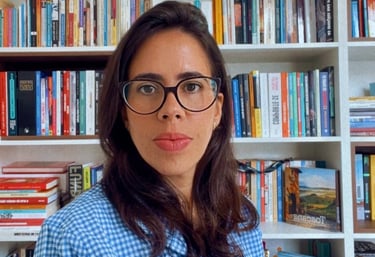 a woman in a blue shirt and glasses in your library
