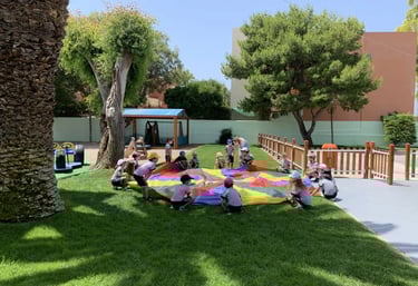 παιδια παιζουν στο γκαζον σε παιδικο σταθμο