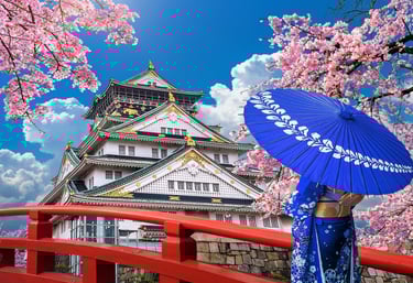 Osaka castle with cherry blossoms with woman in traditional kimono with umbrella