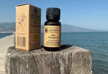 a bottle of orange essential oil sitting on a wooden post