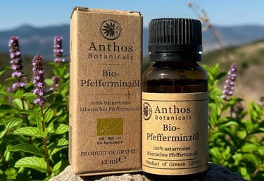 a bottle and a box of peppermint essential oil on a rock in a peppermint field