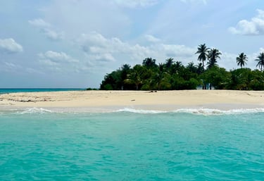 Pristine white sand beach with turquoise waters and swaying palm trees on Hulhudheli Island, Maldive