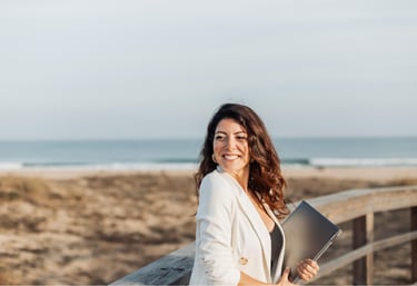 a woman in a white blazer and a laptop computer