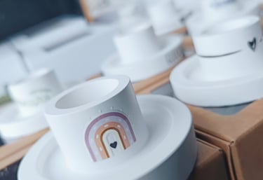 eine Auswahl an handgefertigten, weißen Kerzenhaltern mit individuellen Verziehrungen
