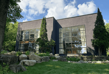 a large house with a large window and a stone wall