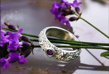 Rankų darbo Viju Jewelry sidabrinis sužadėtuvių žiedas su ametistu, padėtu ant levandų stiebelių.