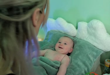 bébé souriant et heureux regardant dans les yeux de la praticienne