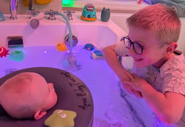 frère heureux qui regarde son petit frère dans le bain