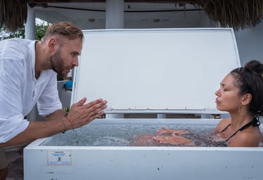 Eine junge Frau in tiefer Entspannung im Eisbad begleitet von einem Wim Hof Instruktor