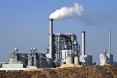 an industry built above the ground with various pipelines ans somke is coming out from one.