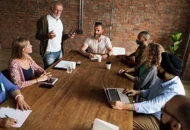 a group of office workers sitting around a table for training