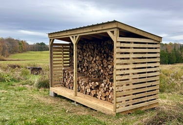 a chord of chopped wood logs stacked on top of each other in a wooden storage shed