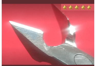 Um alicate de cutícula amolado e polido em um fundo vermelho