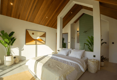 Cozy bedroom with wooden ceiling and an open shower with green tiles